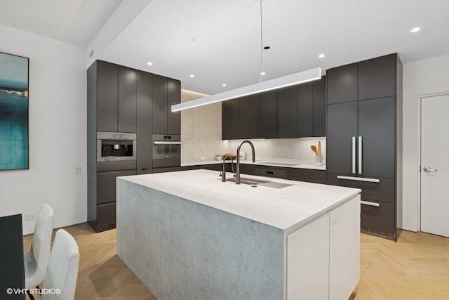 1917 S Calumet Ave, Chicago, IL 60616 - kitchen with modern cabinets, a sink, stainless steel oven, light countertops, and an island with sink