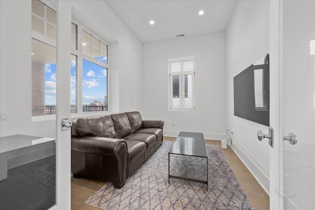 living room with wood finished floors, baseboards, and recessed lighting
