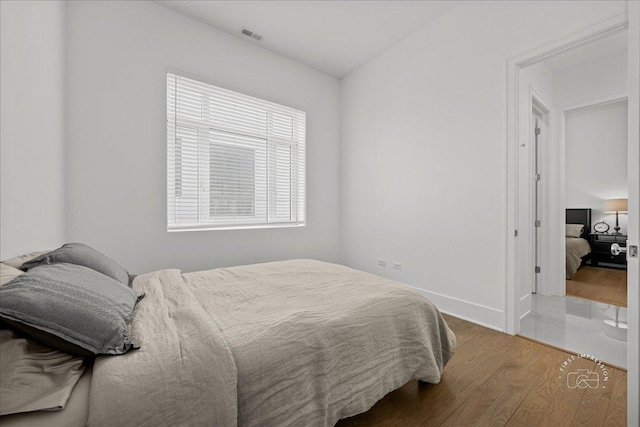 bedroom with wood finished floors and baseboards