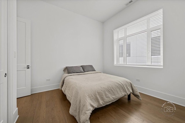 bedroom featuring baseboards and wood finished floors
