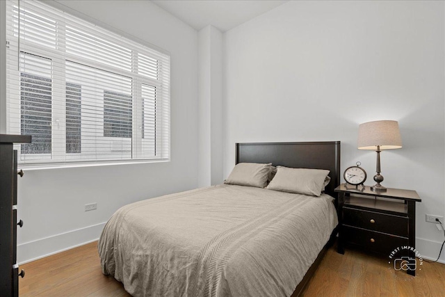 bedroom with wood finished floors and baseboards