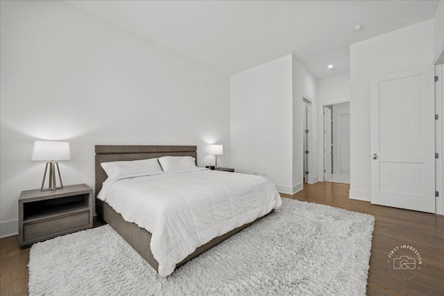 bedroom with wood finished floors, recessed lighting, and baseboards
