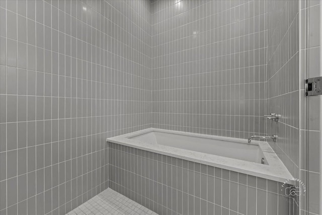 bathroom featuring tile walls, tiled shower, and a bathtub