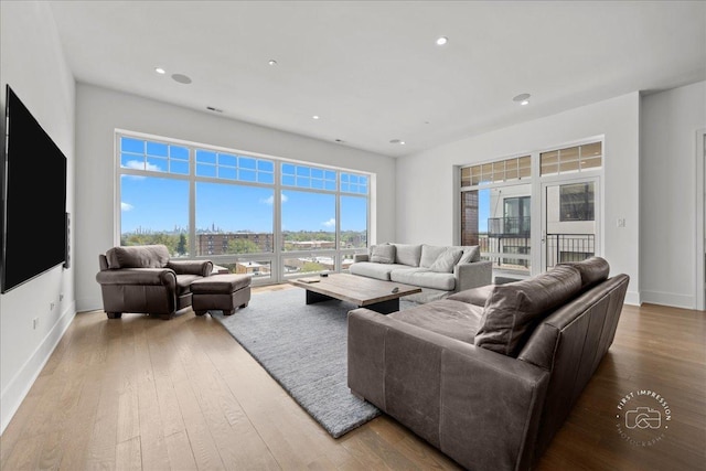 living area with hardwood / wood-style floors, baseboards, and recessed lighting