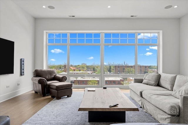 living area with wood finished floors, recessed lighting, and baseboards