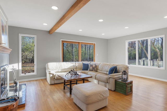 living room featuring baseboards, recessed lighting, light wood-style floors, and beam ceiling