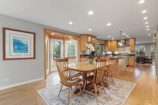 dining area with recessed lighting, light wood-style flooring, and baseboards
