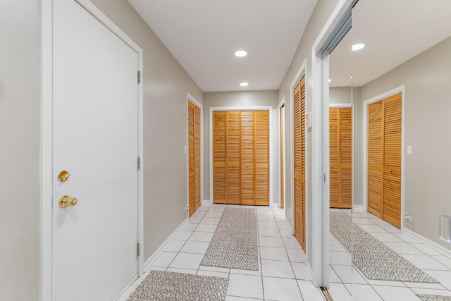 hallway with recessed lighting, baseboards, and light tile patterned flooring