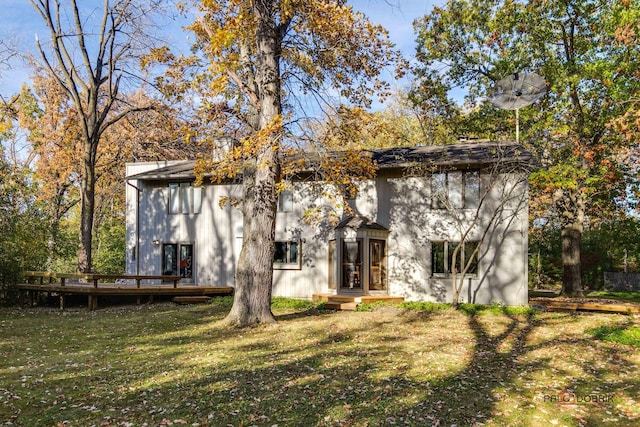 back of house featuring a lawn and a deck