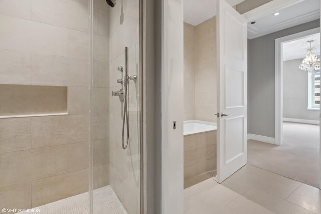 118 E Erie St Unit 19C, Chicago, IL 60611 - bathroom with tile patterned floors, a shower stall, a garden tub, and a chandelier
