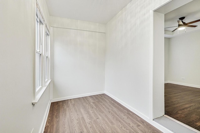 empty room featuring baseboards, ceiling fan, and wood finished floors
