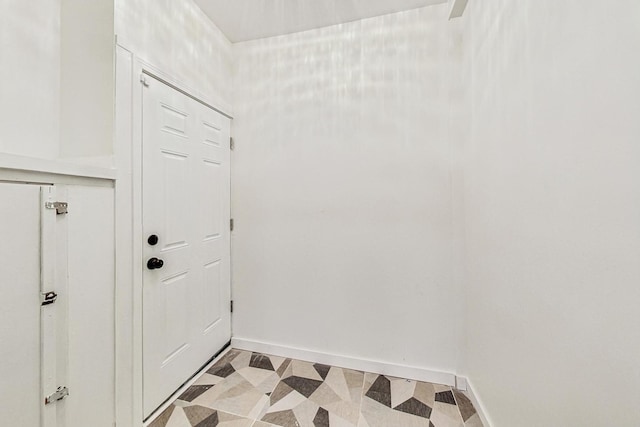doorway with baseboards and light floors