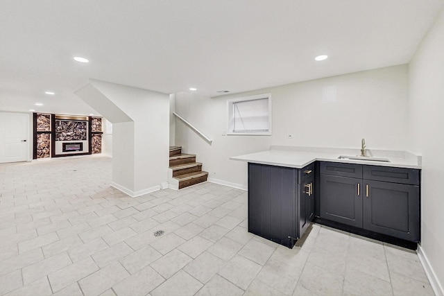 bar featuring baseboards, a sink, recessed lighting, and stairway