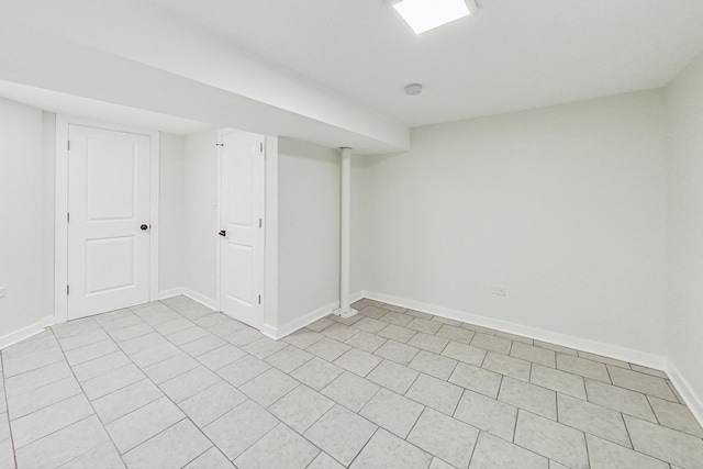 finished basement with baseboards and light tile patterned flooring