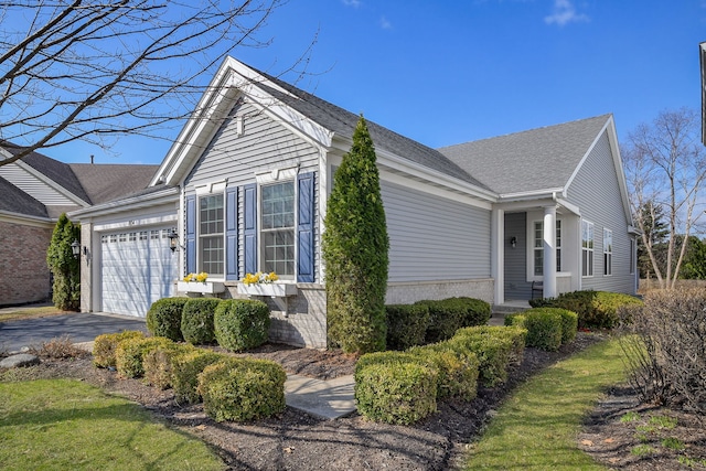 view of home's exterior with a garage, a shingled roof, and driveway
