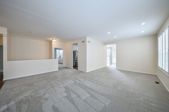 unfurnished living room featuring recessed lighting, baseboards, carpet floors, and visible vents