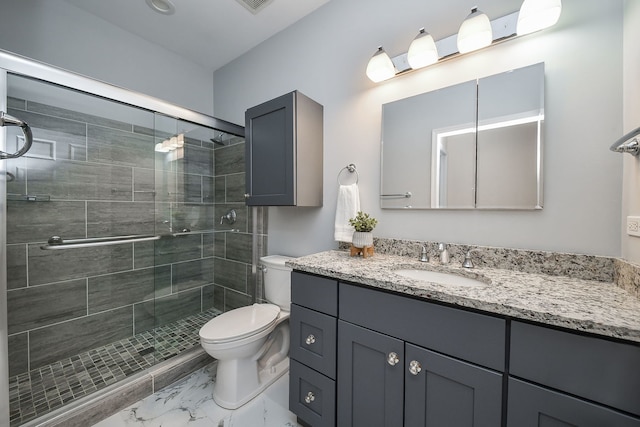 bathroom featuring vanity, marble finish floor, a stall shower, and toilet