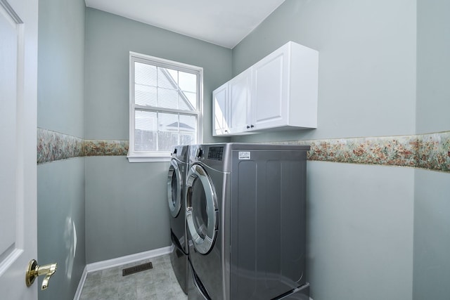 washroom with cabinet space, baseboards, visible vents, and washing machine and dryer