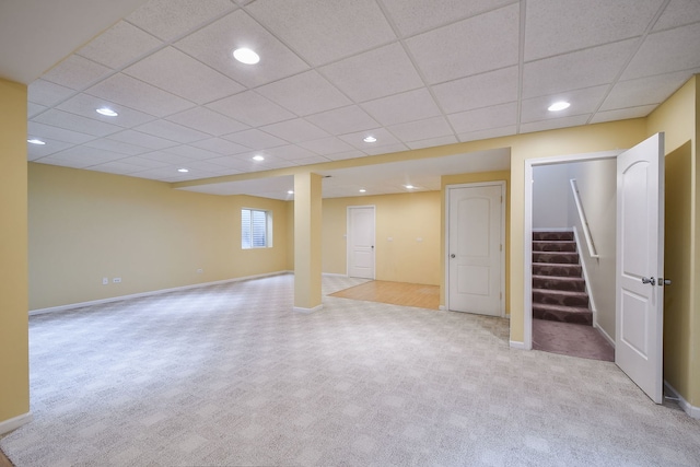 below grade area featuring carpet floors, baseboards, and stairs
