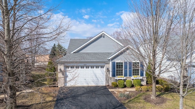 view of front facade featuring an attached garage, roof with shingles, and driveway