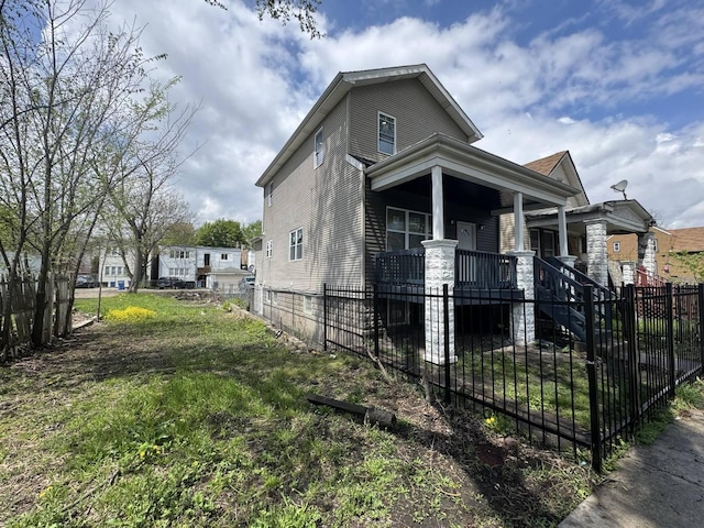 view of front of home with covered porch, a fenced front yard, and stairs