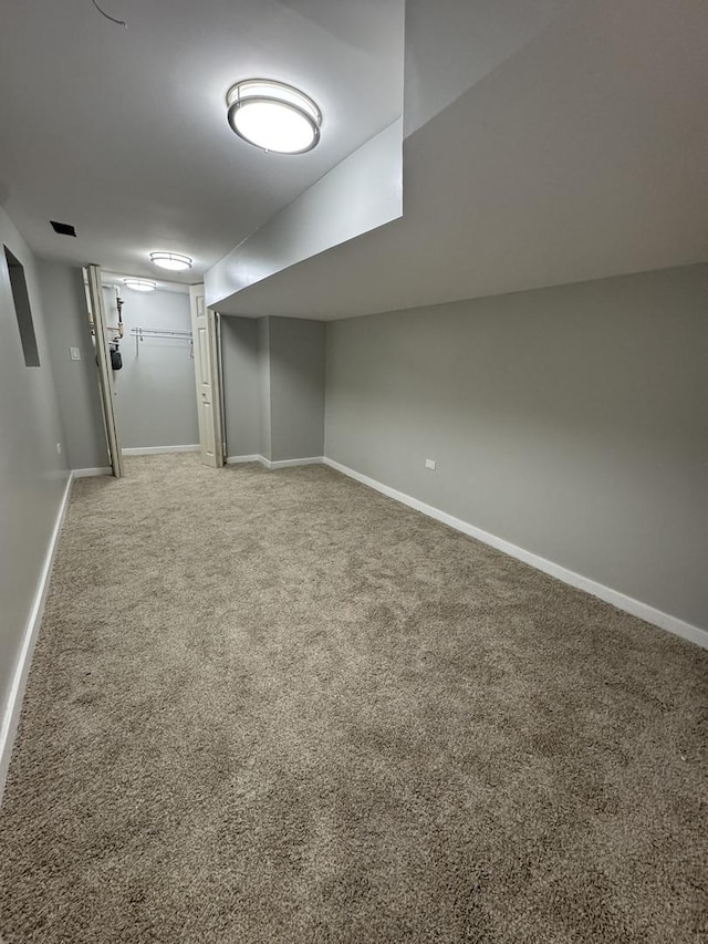 finished below grade area with light colored carpet and baseboards