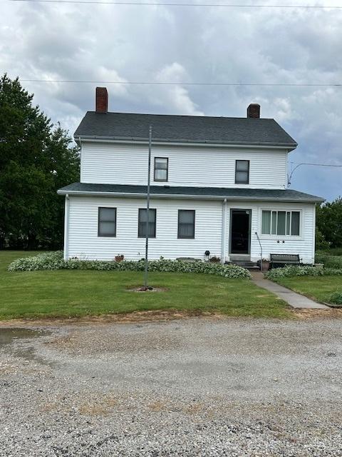 view of front of property with a front yard, a chimney, and entry steps