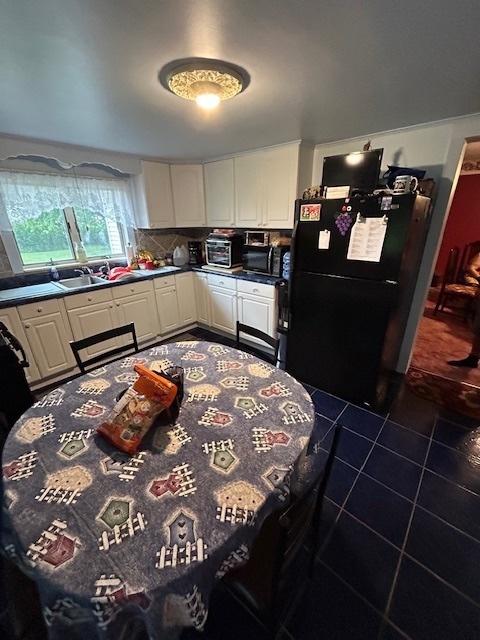 19364 US Highway 34, Princeton, IL 61356 - kitchen with black appliances, white cabinetry, dark tile patterned flooring, a sink, and dark countertops