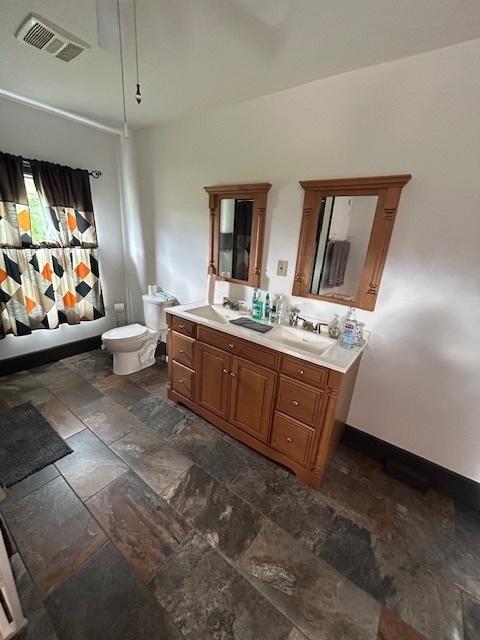 19364 US Highway 34, Princeton, IL 61356 - bathroom featuring stone tile floors, double vanity, and toilet