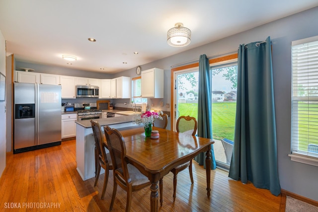 dining space with recessed lighting, light wood-style flooring, and baseboards