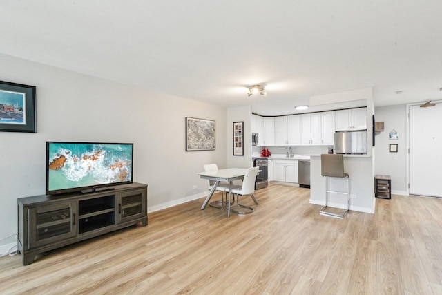 400 E Randolph St Unit 2424, Chicago, IL 60601 - kitchen with light countertops, white cabinets, a sink, light wood finished floors, and appliances with stainless steel finishes