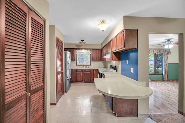1106 Riverside Ct, Mahomet, IL 61853 - kitchen featuring stainless steel fridge with ice dispenser, white electric stove, light countertops, a peninsula, and under cabinet range hood