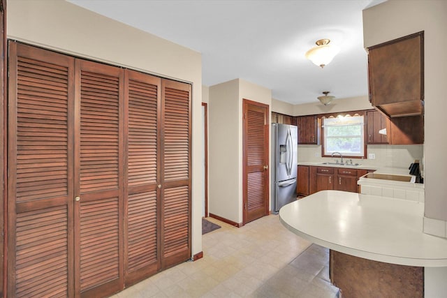 1106 Riverside Ct, Mahomet, IL 61853 - kitchen featuring stainless steel refrigerator with ice dispenser, light countertops, light flooring, tasteful backsplash, and a peninsula