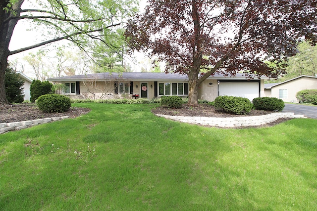 ranch-style house with a garage, a front lawn, and driveway