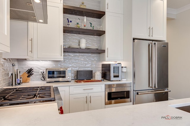 kitchen with light countertops, backsplash, a toaster, and stainless steel appliances