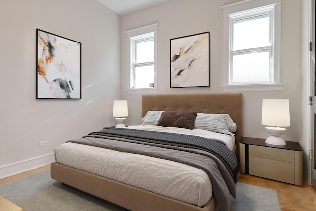 bedroom with baseboards and wood finished floors