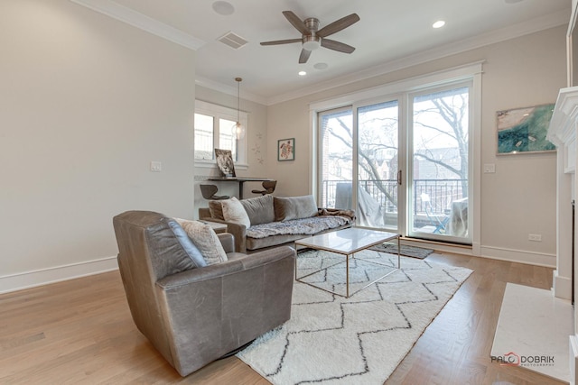 living area with baseboards, ornamental molding, light wood-style flooring, and ceiling fan