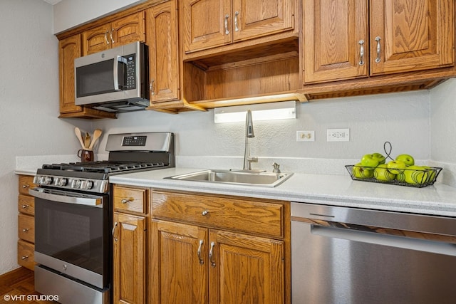 965 Sycamore Ct, Hoffman Estates, IL 60192 - kitchen with appliances with stainless steel finishes, a sink, light countertops, brown cabinets, and a textured wall
