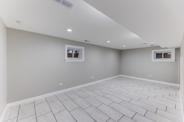 finished basement with baseboards, recessed lighting, and visible vents