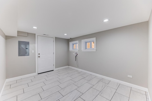 interior space with baseboards, recessed lighting, and electric panel