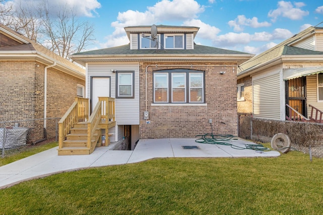 rear view of house with a patio, a yard, and brick siding