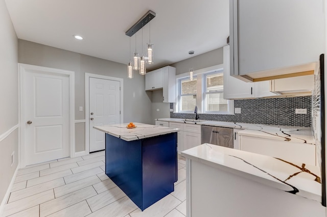 kitchen with backsplash, decorative light fixtures, a center island, dishwasher, and light stone counters