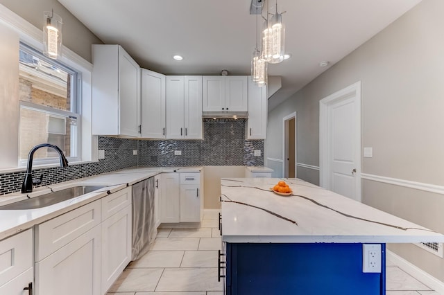 kitchen featuring white cabinets, decorative light fixtures, decorative backsplash, and a sink