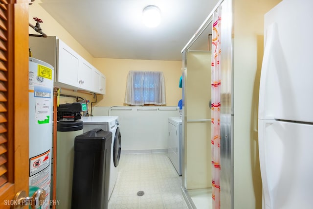 laundry area with cabinet space, separate washer and dryer, light floors, and gas water heater