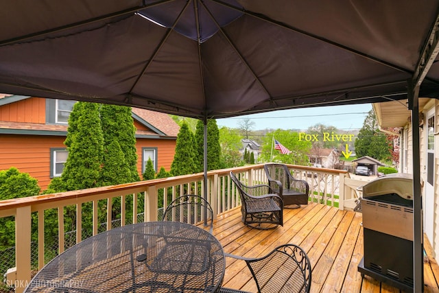 wooden deck with outdoor dining area and a grill