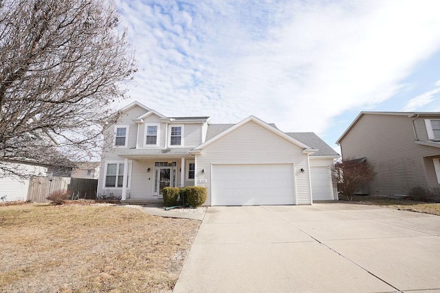 traditional-style home featuring an attached garage, fence, and concrete driveway