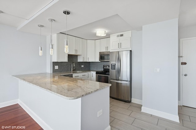 1460 N Sandburg Ter Unit 2608A, Chicago, IL 60610 - kitchen featuring light stone countertops, appliances with stainless steel finishes, a sink, a peninsula, and white cabinetry