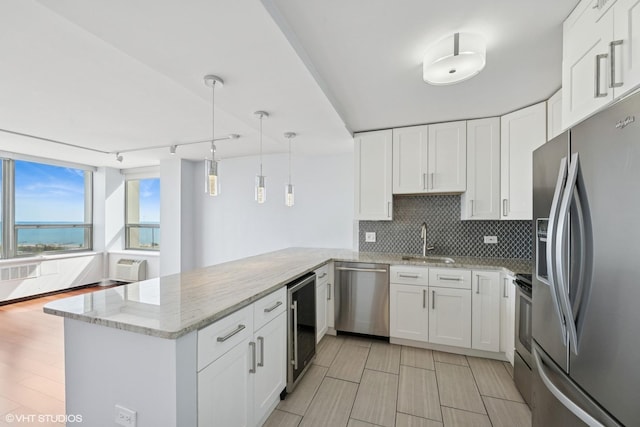 1460 N Sandburg Ter Unit 2608A, Chicago, IL 60610 - kitchen featuring a sink, white cabinets, a peninsula, wine cooler, and stainless steel appliances