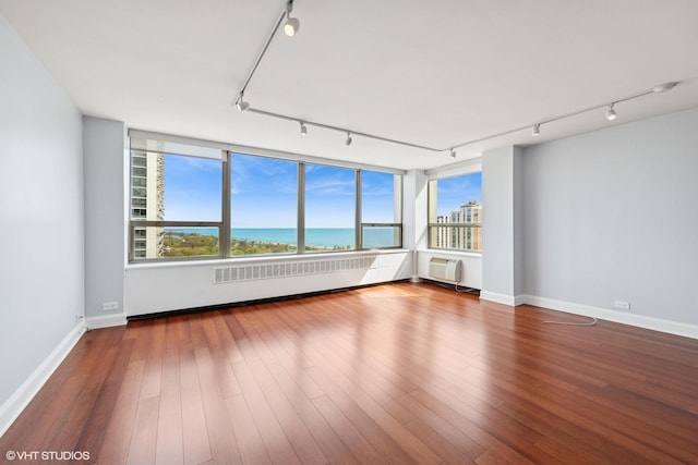 1460 N Sandburg Ter Unit 2608A, Chicago, IL 60610 - spare room with baseboards, rail lighting, a healthy amount of sunlight, and wood finished floors