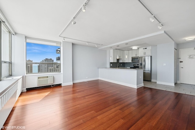 1460 N Sandburg Ter Unit 2608A, Chicago, IL 60610 - unfurnished living room featuring light wood-style floors, rail lighting, baseboards, and a wall mounted air conditioner